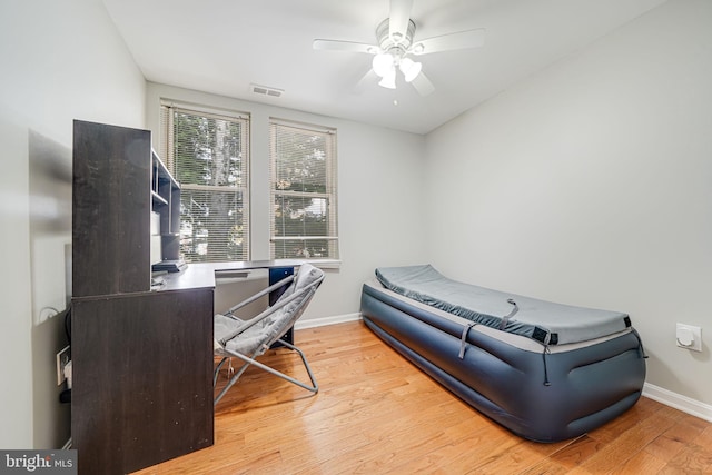 bedroom featuring wood finished floors, visible vents, baseboards, and ceiling fan