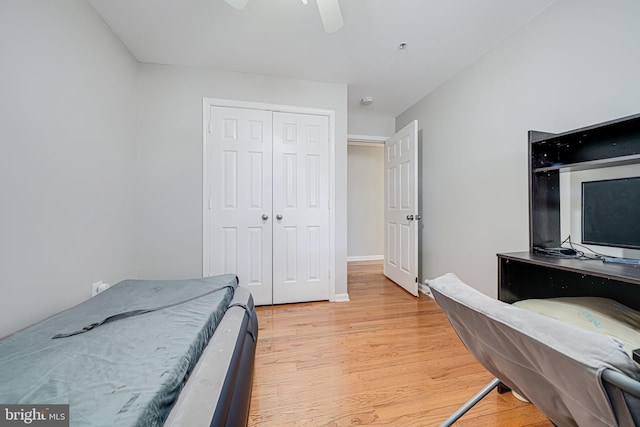 bedroom with ceiling fan, light wood-style floors, and a closet