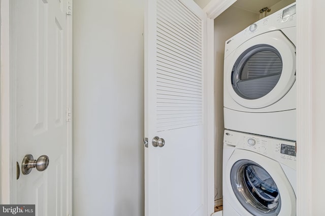 laundry room featuring stacked washer / dryer and laundry area