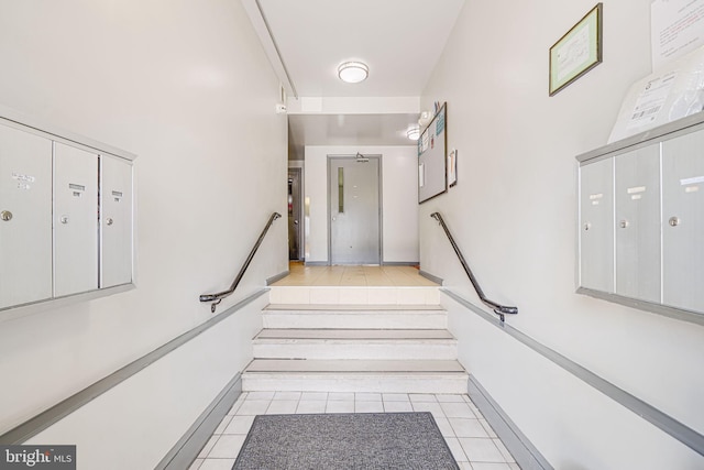 staircase with mail area and tile patterned flooring