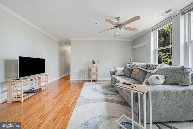 living area featuring ceiling fan, visible vents, light wood-type flooring, and ornamental molding