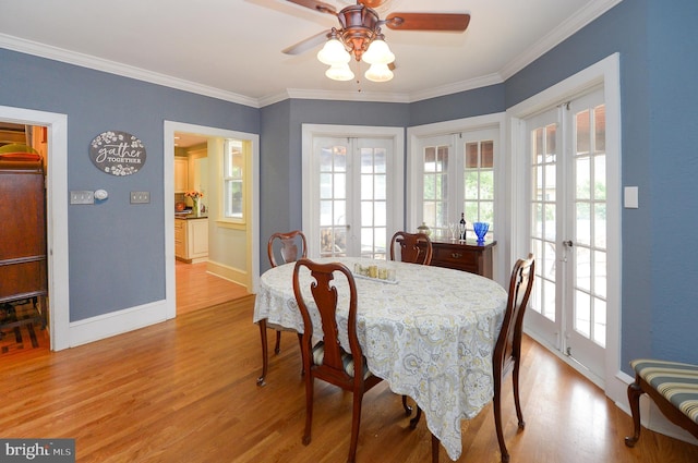 dining area featuring french doors, light wood-style floors, ceiling fan, ornamental molding, and baseboards