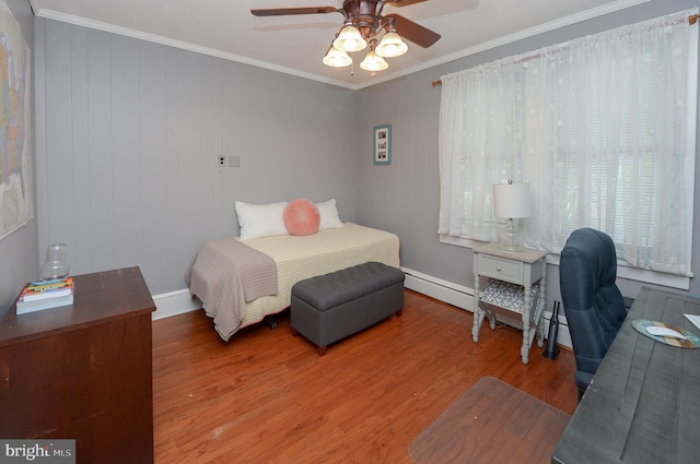 bedroom with wood finished floors, crown molding, ceiling fan, baseboards, and baseboard heating