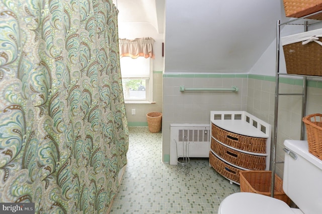 full bathroom featuring tile walls, toilet, radiator heating unit, wainscoting, and tile patterned floors