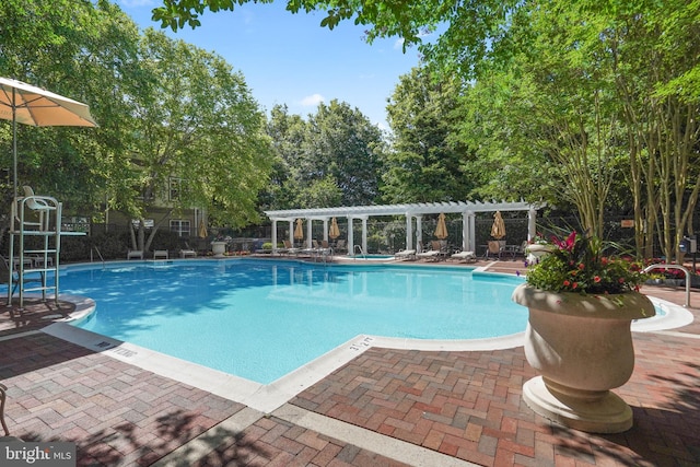community pool with a pergola and a patio area