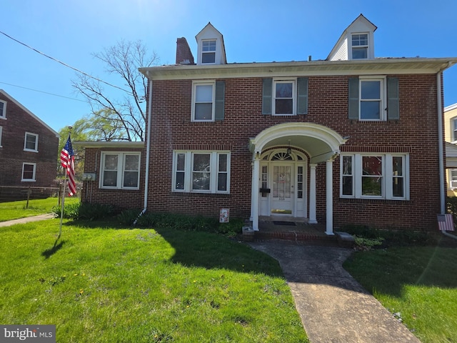 view of front facade with a front lawn and brick siding