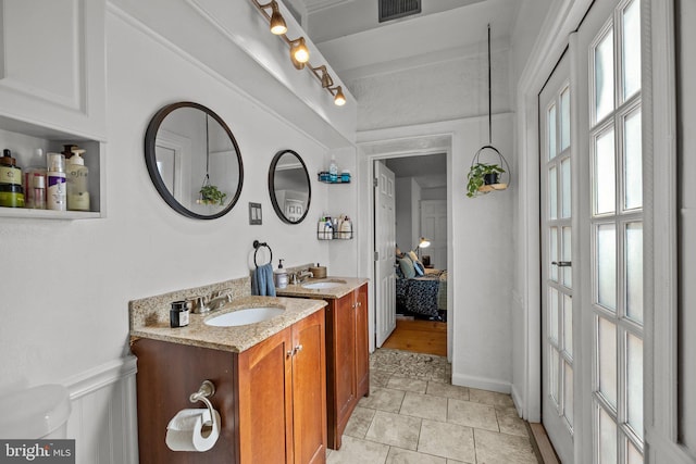 ensuite bathroom featuring visible vents, connected bathroom, and vanity