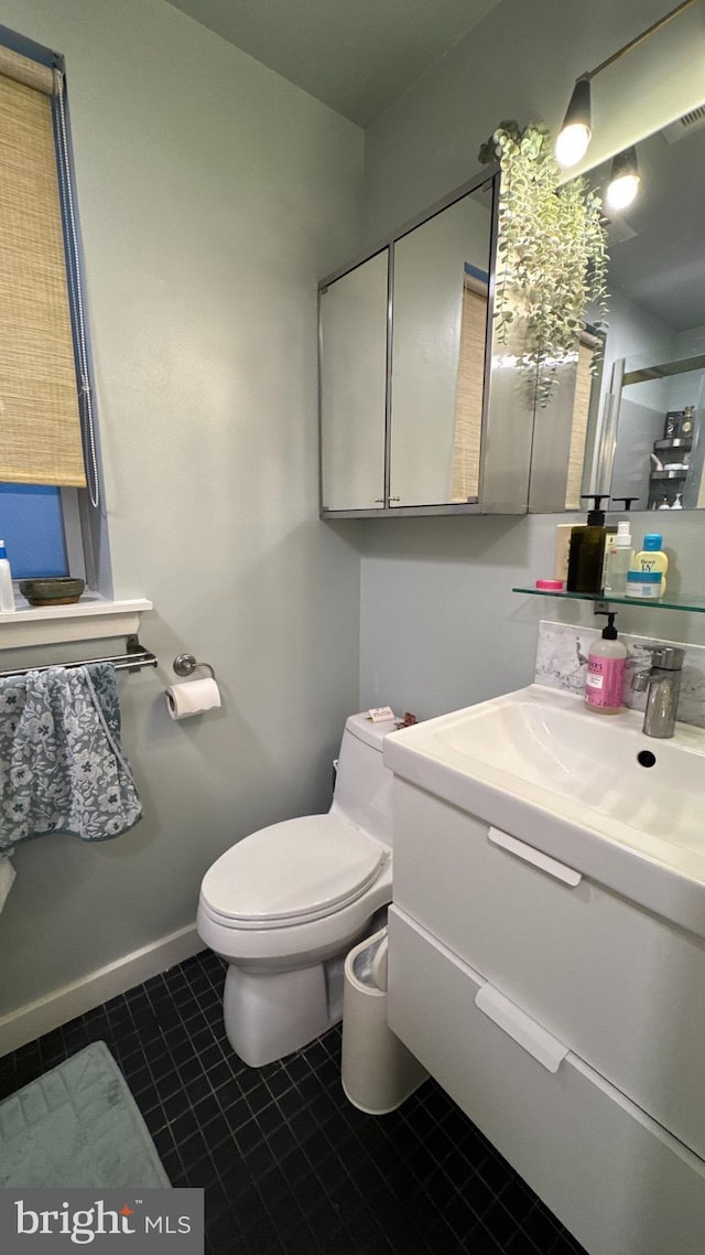 bathroom with toilet, visible vents, baseboards, tile patterned flooring, and vanity