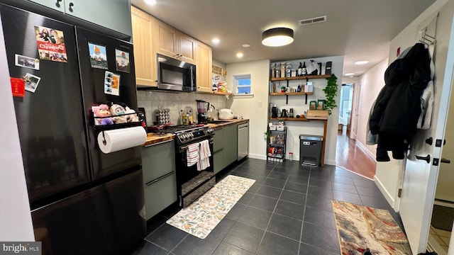 kitchen with backsplash, appliances with stainless steel finishes, visible vents, and dark tile patterned flooring
