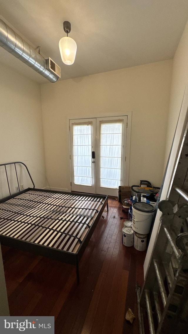 bedroom with hardwood / wood-style floors and french doors