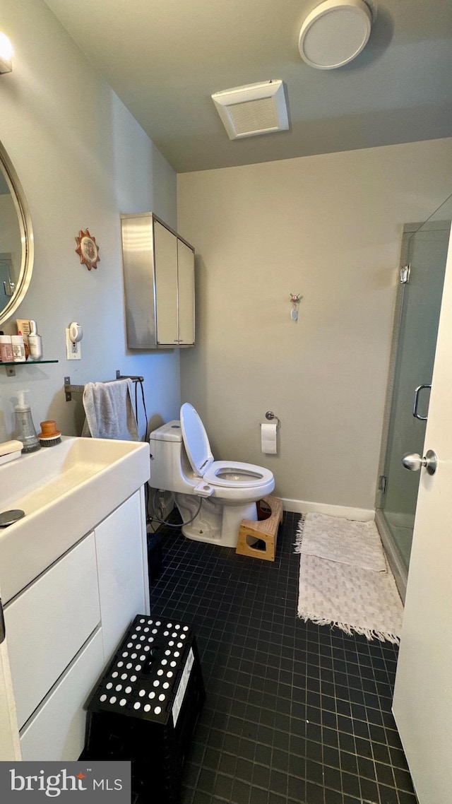 full bath featuring toilet, vanity, tile patterned flooring, and a stall shower
