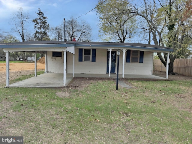 ranch-style house with fence, covered porch, an attached carport, and a front yard