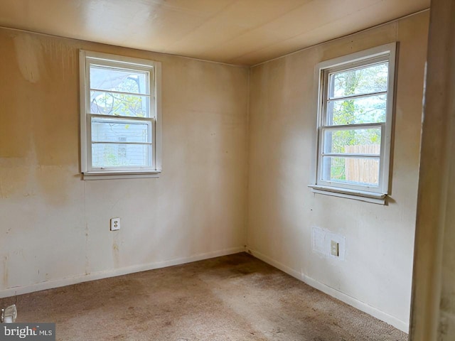 unfurnished room featuring carpet floors, a healthy amount of sunlight, and baseboards