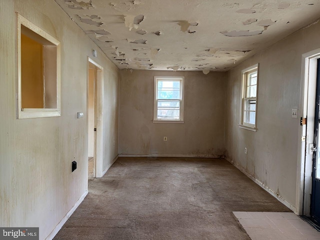 spare room with baseboards and carpet flooring