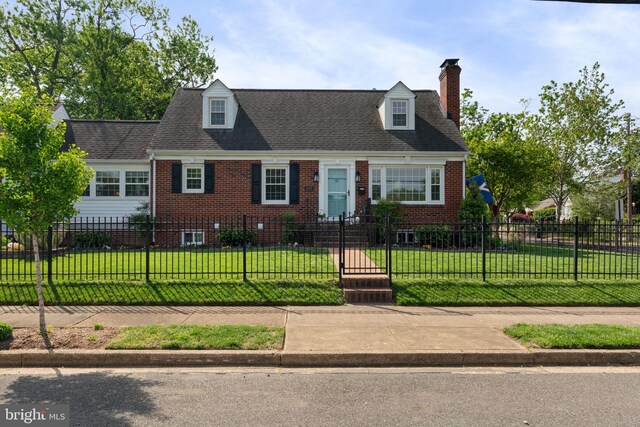 1217 Stafford Ave, Fredericksburg, VA 22401 - cape cod-style house featuring a shingled roof, a fenced front yard, a front lawn, brick siding, and a chimney