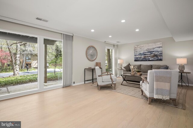 living area with baseboards, visible vents, recessed lighting, and light wood-style floors