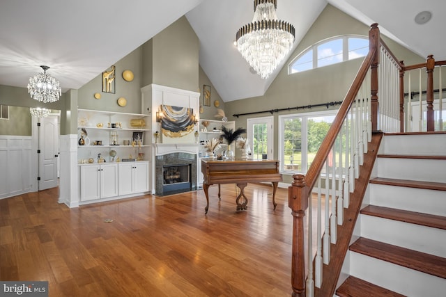 81 Stewart Rd, Pilesgrove, NJ 08098 - staircase with a healthy amount of sunlight, a notable chandelier, high vaulted ceiling, wood finished floors, and a fireplace