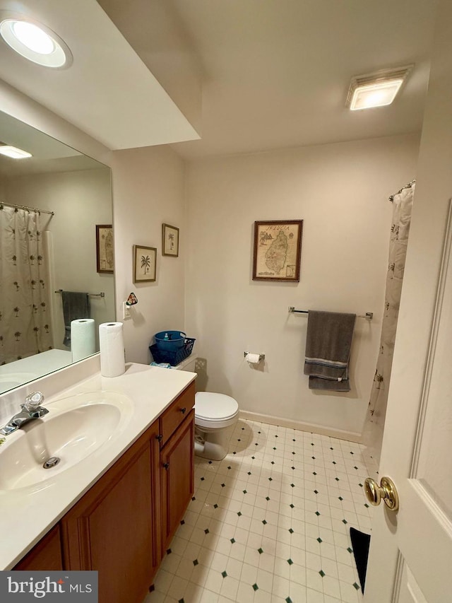 full bathroom featuring vanity, toilet, tile patterned floors, a shower with shower curtain, and baseboards