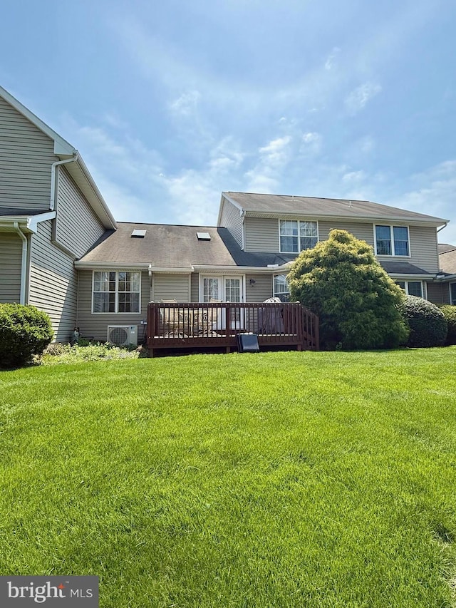back of property with a lawn and a deck