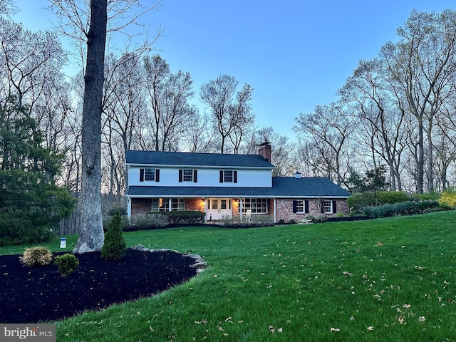 view of front of property with a chimney and a front lawn