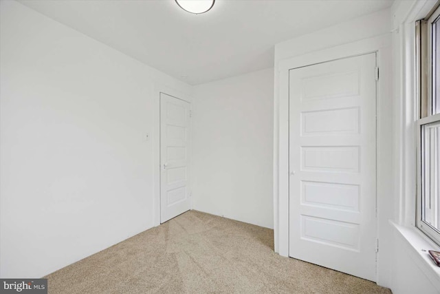 unfurnished bedroom with light colored carpet