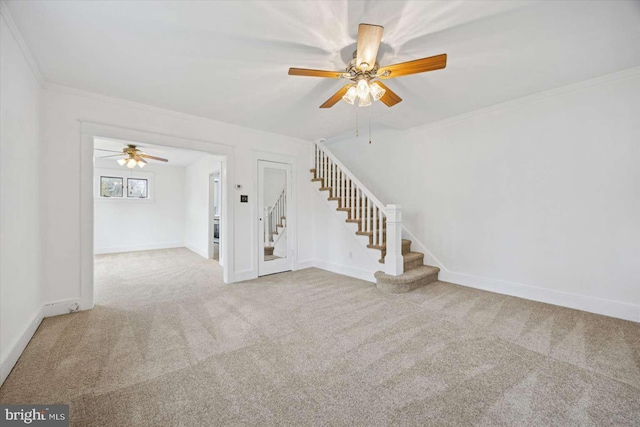 unfurnished living room with a ceiling fan, carpet flooring, stairs, and ornamental molding