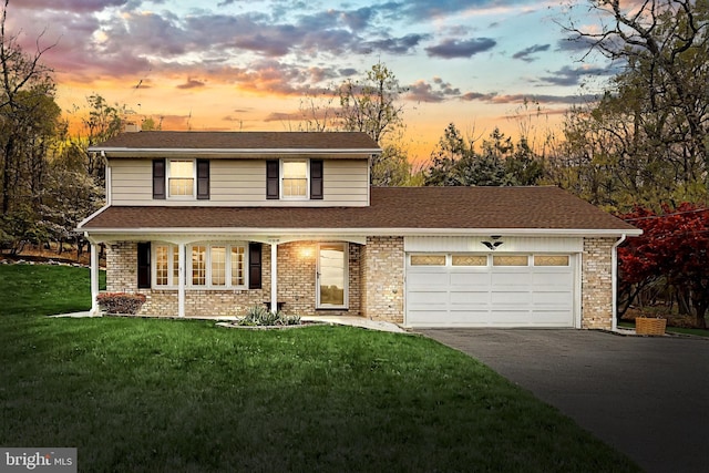 traditional-style house featuring aphalt driveway, an attached garage, covered porch, brick siding, and a front yard