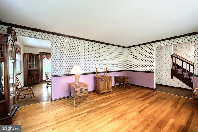 interior space featuring stairs, ornamental molding, and wood finished floors