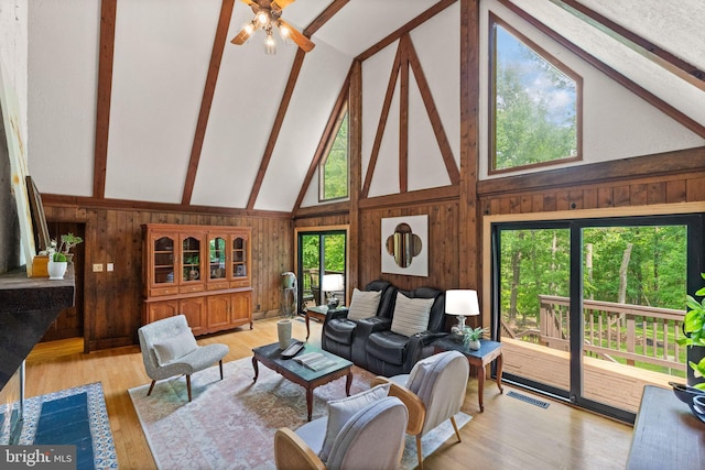 11713 Henderson Rd, Clifton, VA 20124 - living area with beam ceiling, ceiling fan, wood walls, high vaulted ceiling, and light wood finished floors