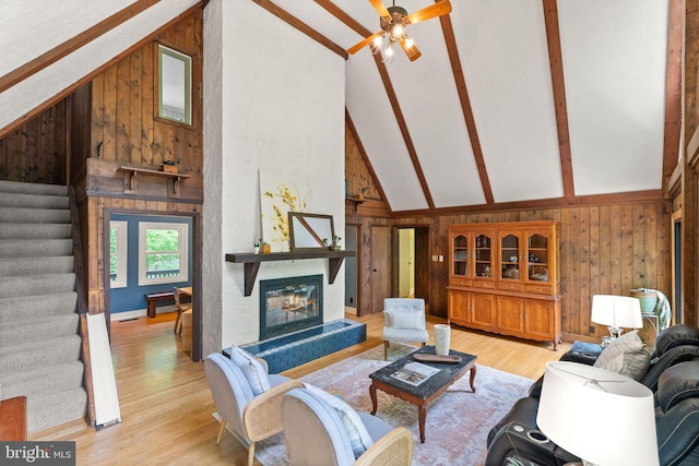 11713 Henderson Rd, Clifton, VA 20124 - living room featuring wood walls, stairs, beamed ceiling, light wood-style floors, and a ceiling fan