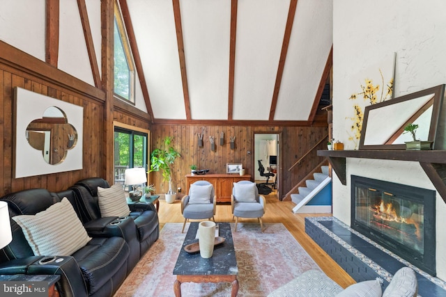 11713 Henderson Rd, Clifton, VA 20124 - living room featuring wood walls, beam ceiling, high vaulted ceiling, wood finished floors, and a glass covered fireplace
