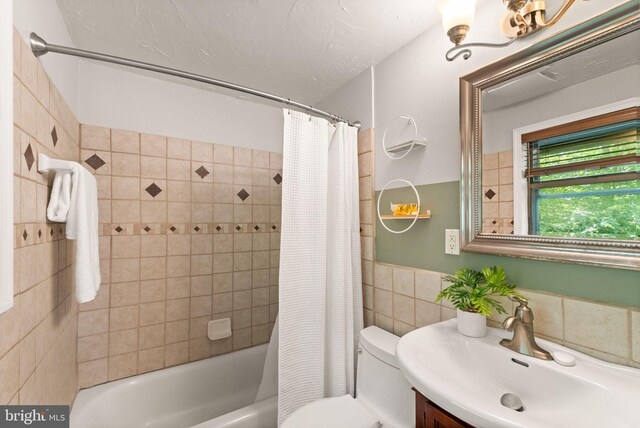 11713 Henderson Rd, Clifton, VA 20124 - full bathroom with tile walls, toilet, shower / bathtub combination with curtain, vanity, and wainscoting