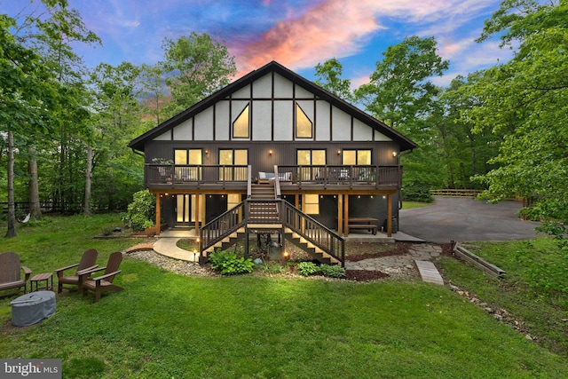 11713 Henderson Rd, Clifton, VA 20124 - back of property at dusk with stairway, a wooden deck, a yard, and a patio
