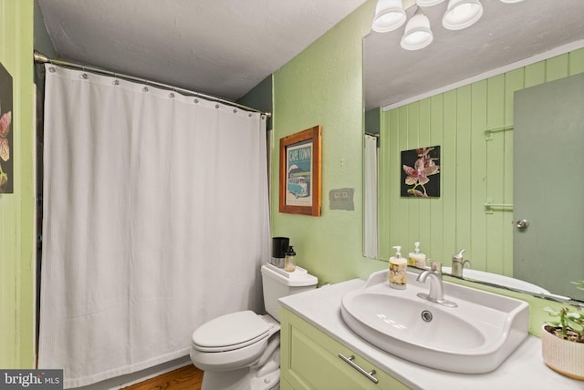 11713 Henderson Rd, Clifton, VA 20124 - bathroom featuring vanity, toilet, a textured wall, wood finished floors, and curtained shower