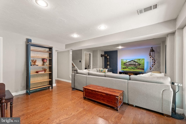11713 Henderson Rd, Clifton, VA 20124 - living area featuring a wood stove, recessed lighting, light wood-style floors, baseboards, and stairway