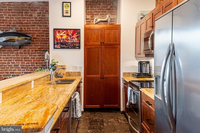 kitchen with a sink, brown cabinetry, marble finish floor, stainless steel appliances, and light stone countertops