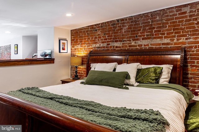 bedroom featuring brick wall and recessed lighting