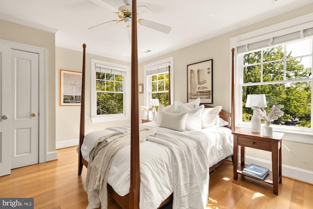 bedroom with crown molding, light wood-style flooring, ceiling fan, and baseboards