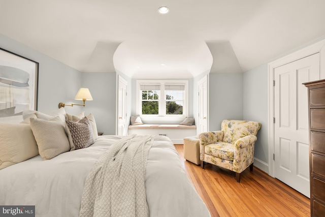 bedroom with baseboards, recessed lighting, and light wood-style flooring
