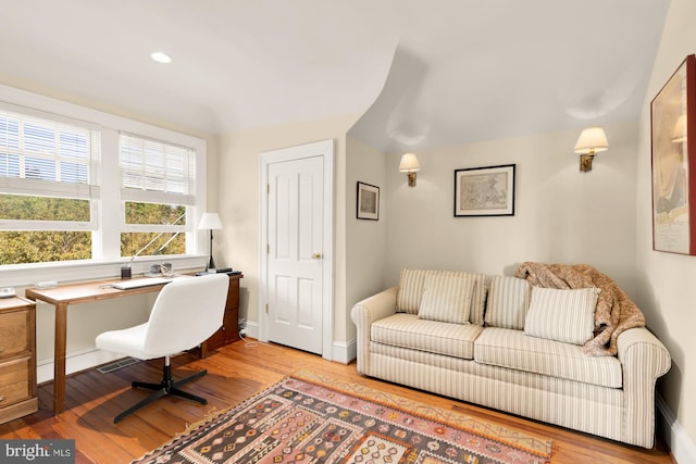 home office with baseboards and wood finished floors