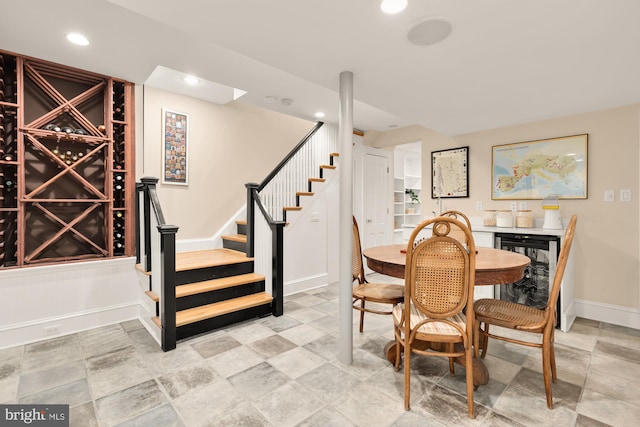 dining room with stairs, baseboards, wine cooler, indoor bar, and recessed lighting