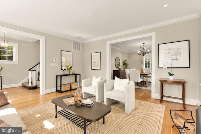 living area with visible vents, a chandelier, stairway, and light wood-type flooring