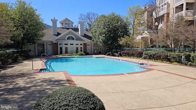 community pool featuring fence and a patio