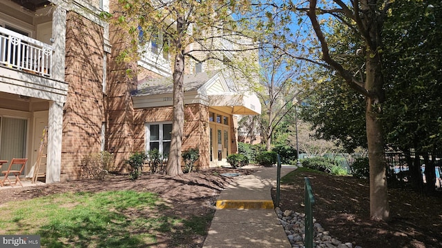 view of side of property featuring fence and a balcony