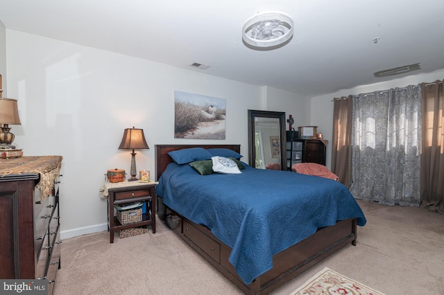 bedroom with baseboards, light carpet, and visible vents