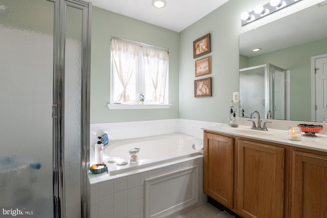 full bathroom with vanity, a shower stall, and a garden tub