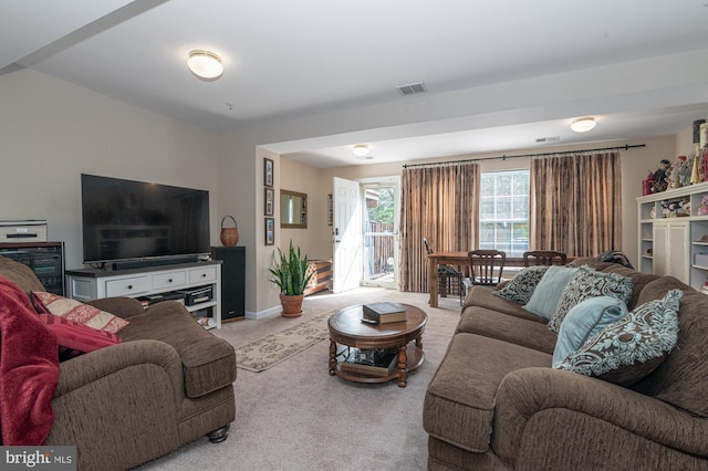 carpeted living room with baseboards and visible vents