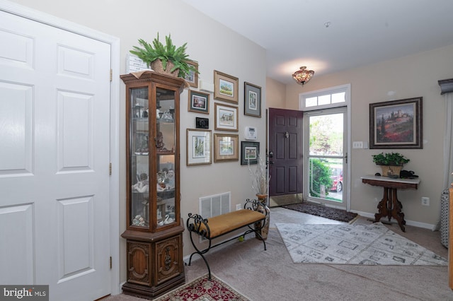 carpeted entryway with baseboards and visible vents