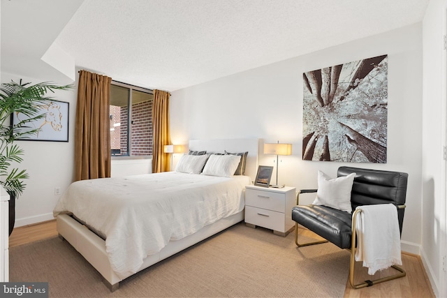 bedroom featuring baseboards and light wood finished floors