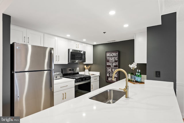kitchen featuring recessed lighting, a sink, white cabinets, and stainless steel appliances